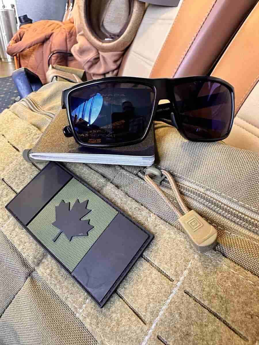FortKnight Optics 308 Free Range sunglasses resting on a Canadian passport, worn through years of international travel.